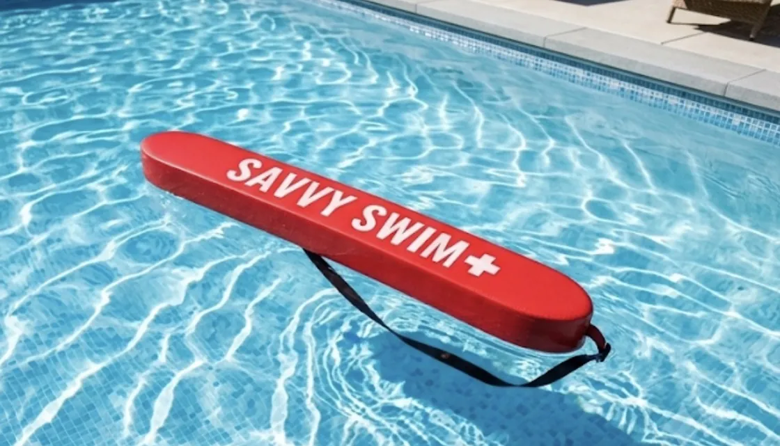 Red Savvy Swim rescue tube on the pool deck